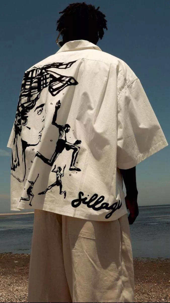 Back view of a male model wearing a white graphic shirt